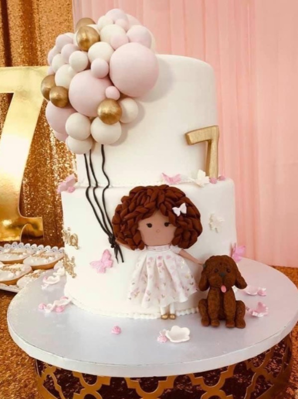 Custom birthday cake with a fondant girl, balloons, and puppy
